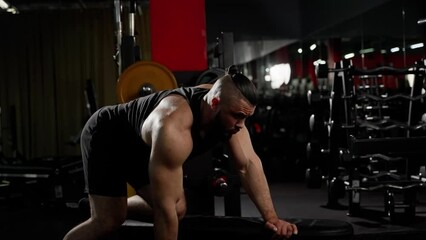 Muscular man performing single-arm dumbbell row in gym, showcasing strength and focus during intense workout - Powered by Adobe