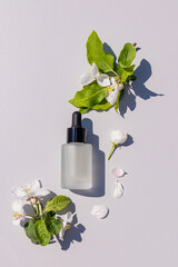 A matte bottle of a cosmetic product for daily face and body skin care on a light background among...