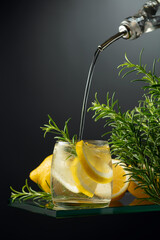Cocktail gin tonic with ice, lemon, and rosemary.