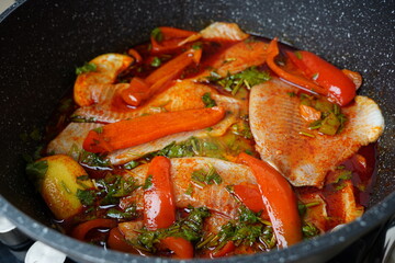 Moroccan fish  with chermoula, red peppers and preserved lemon cooking process. Spicy traditional  Moroccan food
