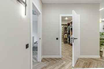 Doorway of modern apartment with white walls and parquet floor