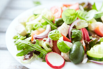 Healthy Salad with Feta Cheese, Green Olives, Cucumber and Cherry Tomatoes. Bright background....