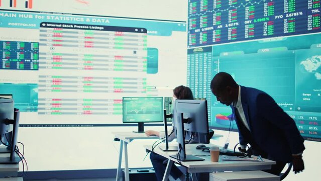 Chief financial officer examining capital funds and revenue data on annual reports in an office with a big screen, reviewing profit increase and budget allocation for a project. Camera B.