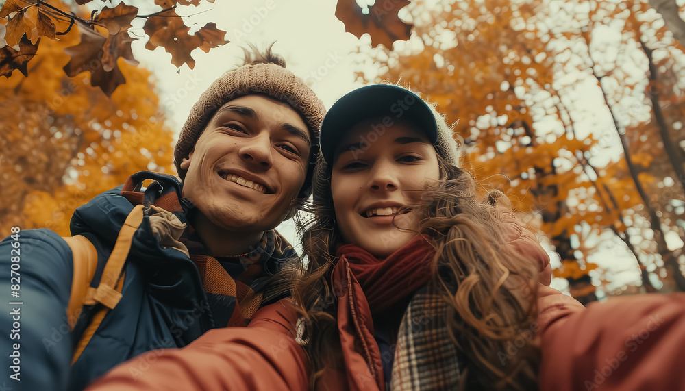 Wall mural A couple posing for a picture in a park with autumn leaves