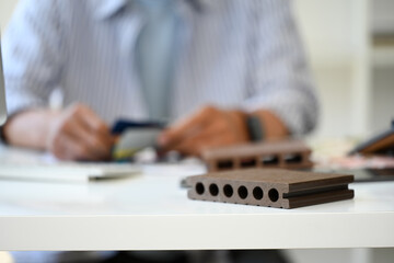 Sample solid wooden battens on white table with interior designer working in background