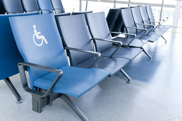 Rows of empty blue seats in public waiting area for people with physical disabilities and people with special needs