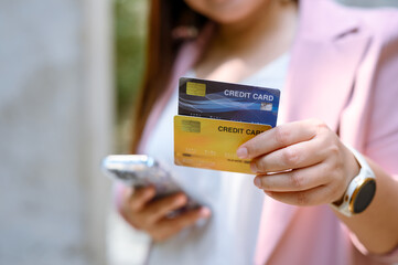 Young Asian woman using credit card and mobile phone for online shopping , technology money wallet and online payment concept, credit card mockup