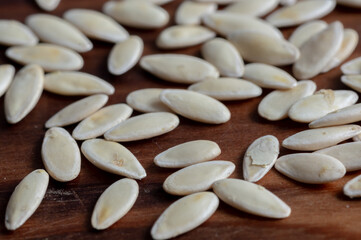 Cucumber seeds on wooden background. Vegetable garden concept
