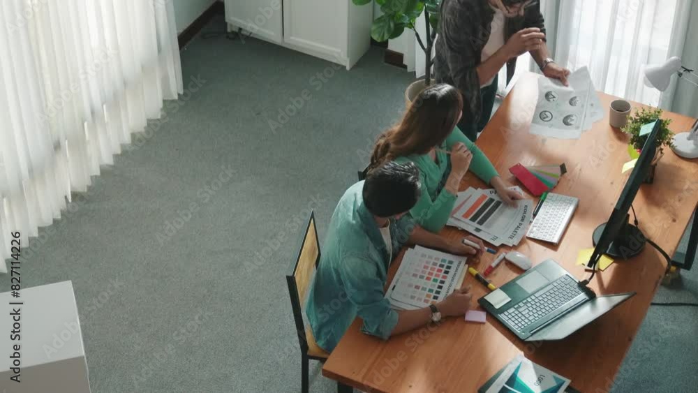 Poster close up of smart business team hands looking at color palette at table while throw paper in the air