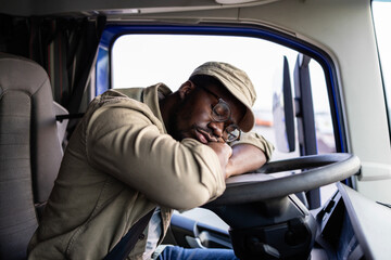 Overworked truck driver fell asleep inside the cabin at parking lot.