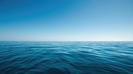 Obraz premium Serene seascape with calm blue waters reflecting the bright blue sky, perfect for relaxing travel.