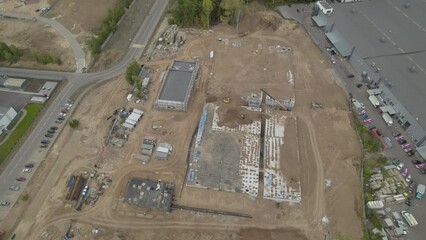 Construction site with hive of activity with swinging crane arm. Transformation example of blueprint of waste treatment plant in reality
