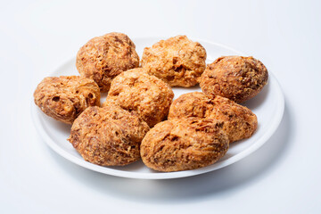Deep fried popular indian snack food ooty varkey on a white plate on a white background. Closeup