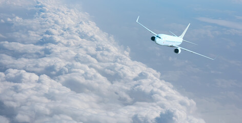 White passenger airplane flying in the sky amazing clouds in the background - Travel by air transport