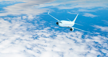 White passenger airplane flying in the sky amazing clouds in the background - Travel by air transport