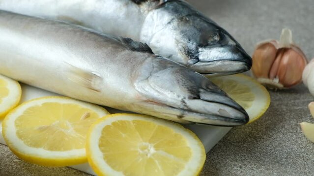 Uncooked mackerel sea fish with lemons and garlic, culinary recipe
