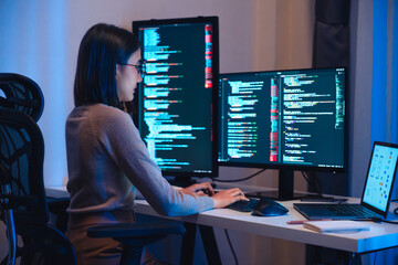 Asian woman  software development working on coding  computer screen and flowchart at night in...
