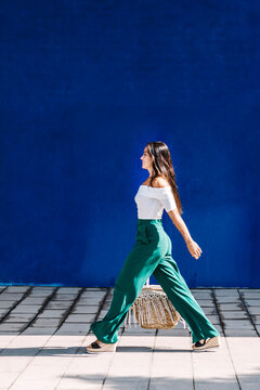 Stylish woman walking on street hands on pocket