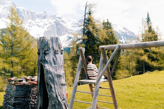 A teenage boy rests after the trek and looks at the mountains