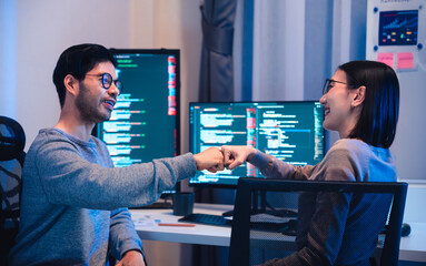 asian and Indian Developer team clapping hand for project success  with software computer at night...