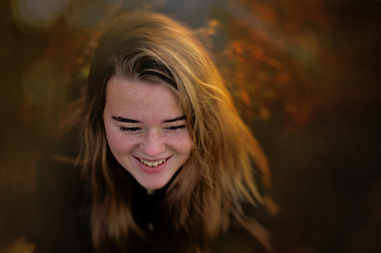 Beautiful happy teen girl with freckles smiling outdoors
