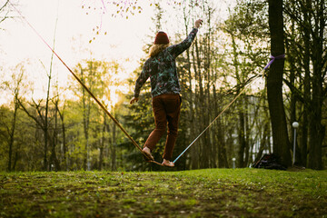 Athletic man trains on a slackline.