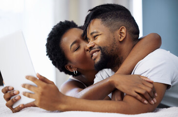 Obraz premium Black couple, bedroom and tablet with love, selfie and kiss for online streaming service, honeymoon or weekend. Young man and woman relax in bed on digital tech for romantic movies or series at home