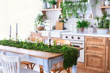 Cozy Wooden cuisine cabinet furniture, utensil, decorations and houseplants on shelves. Dining room with table and chairs. Stylish Interior home kitchen in scandinavian style with green plants in pots
