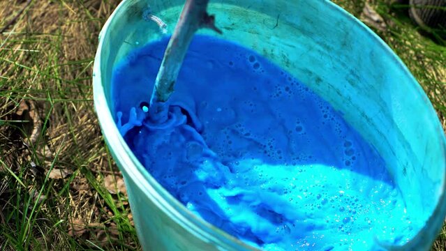 Pesticides and herbicides bred in bucket to treat fruit trees from pests and diseases. Close up herbicides and pesticides for etching trees using agricultural machinery