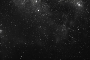 Obraz premium Noise texture that resembles a starlit sky, with small white dots on a dark background to represent stars, and larger, irregular shapes to suggest distant galaxies