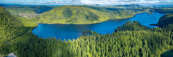 Aerial: Scenic green Lake and Redwood forest Ridgeline, Rotorua, New Zealand