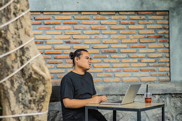 Young asian men, digital nomad working remotely from a cafe, using  smartphone.