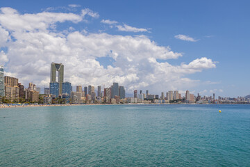 Fototapeta premium Aerial drone photo of the beautiful town of Benidorm in Spain showing the south beach Promenade golden sandy beach and apartments on a sunny summers day with a blue sky and a few clouds