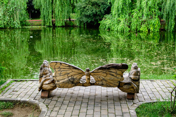 Butterfly bench and vivid landscape in Alexandru Buia Botanical Garden from Craiova in Dolj county, Romania, with river and trees in a beautiful sunny spring day with blue sky and white clouds