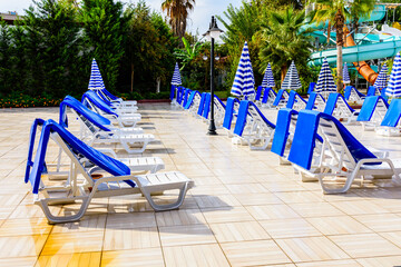 Empty chaise lounges and sun umbrellas near the swimming pool