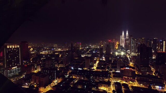 Kuala Lumpur, Malaysia - april 17th, 2024 : panoramic view of Petronas Twin Towers and Kuala Lumpur city skyline buildings midday with sunflare and palm tree. Zoom in wide view