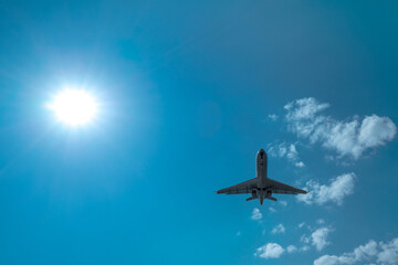 plane landing against the backdrop of the sun and clouds