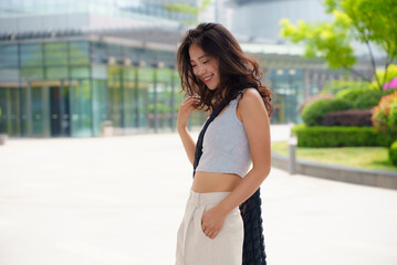 pretty young asian woman at urban city square in summer day