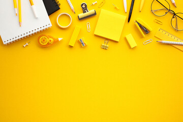 Vibrant office supplies on yellow background. Flay lay composition with sticky notes, paper...