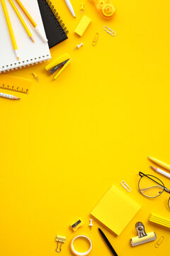 Flat lay modern workspace with office supplies on yellow background. Banner design for themes related to education, organization, and creative workspaces.