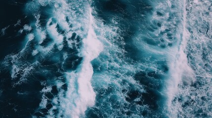 Aerial view of deep blue sea with frothy, swirling ocean waves