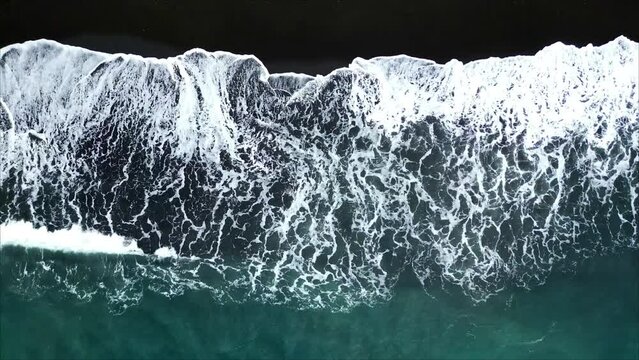 Horizontal Drone Shot of Black Sand Beach in Indonesia. Aerial View Top Down waves crushing