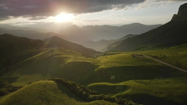 Green mountains in the evening sunlight. Aerial drone view. Summer landscape. Aktoprak pass in North Caucasus, Russia.
