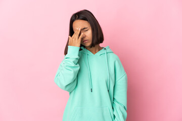 Young latin woman isolated on pink background with headache