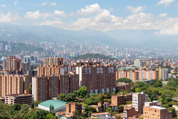 Beautiful panorama (cityscape) of Medellin, Medellín, on a sunny day. The pictures shows condominiums and the Andes Mountains. Antioquia, Colombia. Blue sky, white clouds.