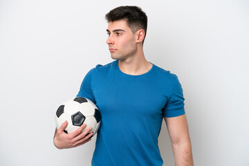 Young caucasian man isolated on white background with soccer ball