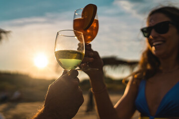 Cheers at Sunset on the Beach - Celebrating Summer Moments - happy couple toasting drinks - Powered by Adobe