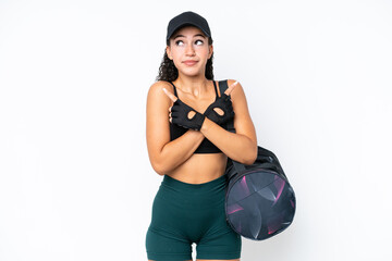 Young sport woman with sport bag isolated on white background pointing to the laterals having doubts