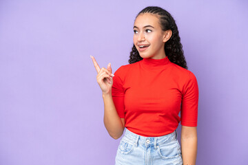 Young woman isolated on purple background intending to realizes the solution while lifting a finger...