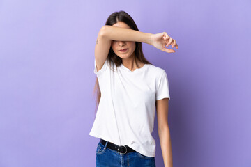 Young caucasian woman isolated on blue background covering eyes by hands